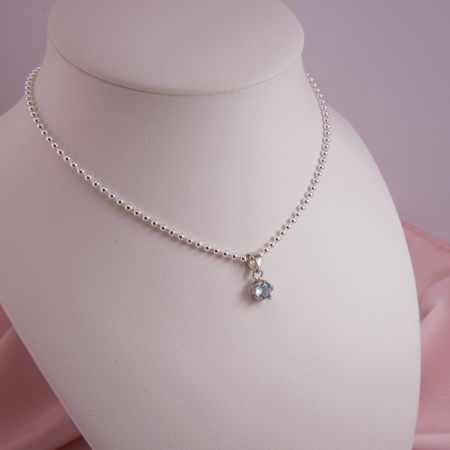 Solitär Edeltopas Anhänger, facettiert, blau auf einer Kugelkette, auf Schmuckbüste präsentiert.